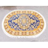 An Eastern wool cut rug, white tassel ends, oval with medallion and border design.