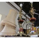 Two turned wooden and gilt table lamps, with cream shades.