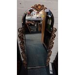 An over mantel mirror, the arch top with gilt shell capped and scroll sides.