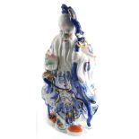 A 20thC Chinese pottery figure, of a bearded sage holding staff, predominantly in blue, orange, and
