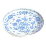 An 18thC Chinese style blue and white pottery dish, decorated with flowers, 35cm diameter.