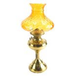 A 20thC brass oil lamp, with amber coloured glass shade, 52cm high.