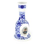 A 19thC pottery decanter, of mallet shape set with a profile of a gentleman with a blue floral backg