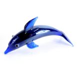 A 20thC Lalique style figure of a dolphin, in blue with white and black eyes, unsigned, 8cm wide.