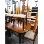 A walnut extending dining table and four various Queen Anne style chairs.