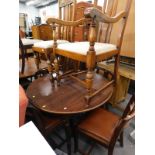 A beech circular dining table and various oak dining chairs.