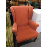 A wing back armchair in rust fabric. The upholstery in this lot does not comply with the 1988 (