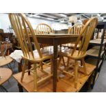 An oak dining table and four lath back chairs.