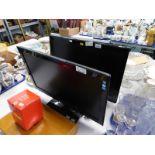 A Hanns.G LCD monitor and a Logik LCD TV with integrated dvd player, both with cables and