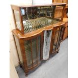 A 1950's/60's walnut display cabinet, the top with two sliding doors above two bow doors, flanking a