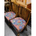 A pair of 1920s oak side chairs, each with a slatted back and loose cushion.