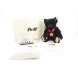 A Steiff Titanic centenary bear, black, 26cm high, with a small model of the Titanic, boxed with cer