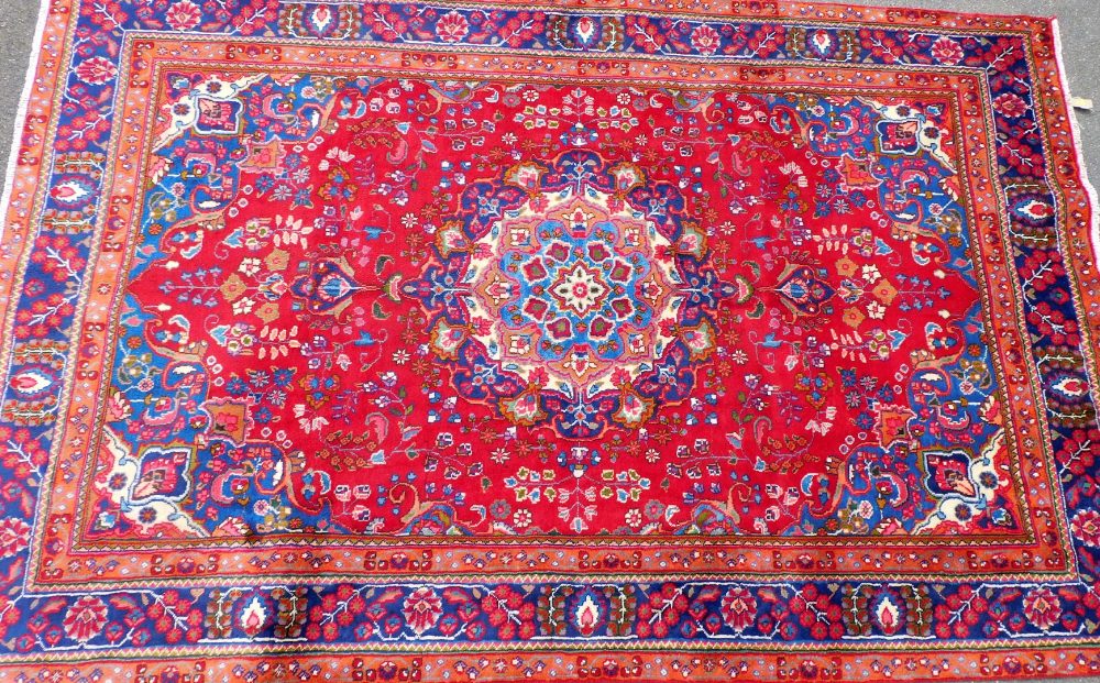 A Persian Tabraz carpet, on a red ground, 285cm x 185cm.