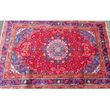 A Persian Tabraz carpet, on a red ground, 285cm x 185cm.
