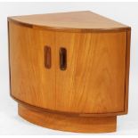 A G-Plan teak bow fronted corner cupboard, raised on a plinth base, 53cm high, 64cm wide, 45.5cm dee