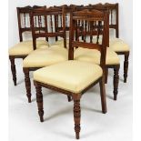 A set of six Edwardian walnut dining chairs, upholstered in overstuffed gold fabric, raised on turne