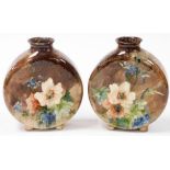 A pair of late 19thC Minton pottery moon flasks, painted with flowers against a brown ground, one be