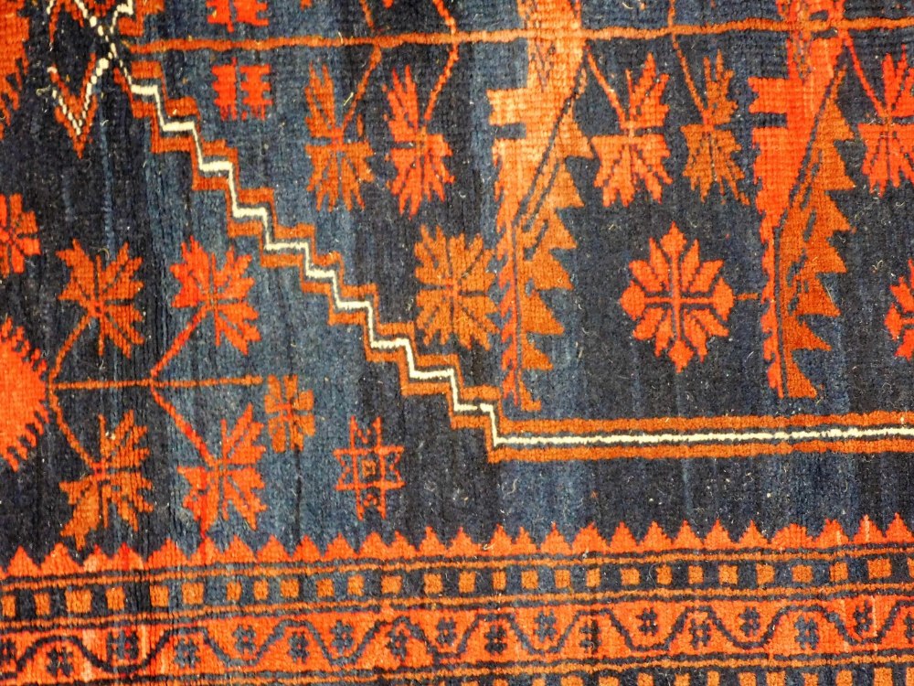 A Caucasian red ground rug, decorated with a central medallion containing floral motifs, within flor - Image 2 of 3