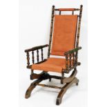 A late 19thC American beech rocking chair, with later upholstery.