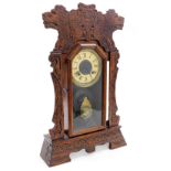 A late 19thC American oak cased mantel clock, gilt tin dial bearing Roman numerals, eight day moveme