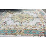 A Chinese cream and turquoise ground carpet, decorated with flowers, 375cm x 280cm.