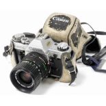 A Canon AE-1 camera, with a zoom lens FD35-70mm 1:3.5-4.5, cased. (AF)