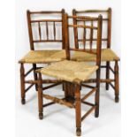 A set of three 19thC oak and rush seated country chairs, raised on turned legs united by a double bo