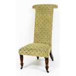 A Victorian mahogany prie dieu chair, upholstered in repeating rose patterned fabric, raised on lapp
