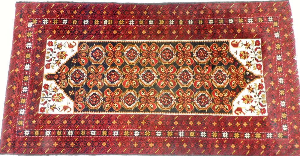 A Persian rug, possibly Quchan, with a central floral and foliate ground, within a red border of rep