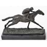 A bronze figure of a jockey and racehorse, on a naturalistic ground, raised on a black marble base,