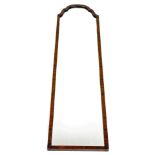 A narrow walnut wall mirror, with an arched top, 121cm high, 30cm wide.