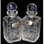 A pair of cut glass decanters and stoppers, with silvered decanter labels engraved for whisky and sh