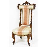 A Victorian walnut prie dieu chair, with foliate carving and bobbin turned back supports, overstuffe