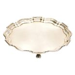 A George V silver salver, with pie crust border raised on three scroll feet, Birmingham 1930, 7¼oz,