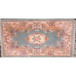 A Chinese turquoise blue ground rug, with floral decoration, 150cm x 78cm.