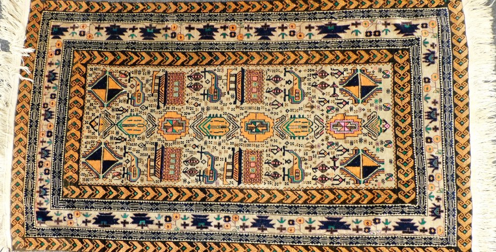 A Baluchi faun ground rug, decorated with guls and other stylised emblems, within repeating geometri