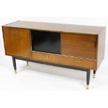 A 1950's G-Plan teak sideboard, with a drop down drinks cabinet, flanked to the right by two sliding