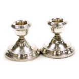 A pair of Elizabeth II silver squat candlesticks, with loaded bases, Birmingham 1962, 7cm high.