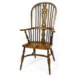 An ash and elm Windsor chair, with a pierced base shaped splat, solid saddle seat, raised on turned