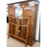 An Edwardian mahogany and inlaid triple wardrobe, the out swept pediment above a central section ins