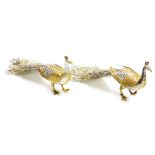 Withdrawn pre-sale by vendor - A pair of silver coloured metal peacocks, with gilt highlights, unmar