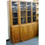 An Art Deco walnut breakfront bookcase, the top with four glazed doors, each enclosing three shelves