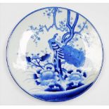 A Japanese blue and white charger, depicting peacock and flowering tree branch, 46cm diameter.