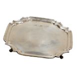 An Elizabeth II silver pie crust salver, raised on four scroll feet, monogram engraved to the front,