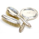 An Edward VII silver mounted three piece dressing table set, comprising mirror, hair brush and hand