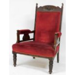 A late Victorian mahogany armchair, upholstered in red Draylon, raised on turned legs.