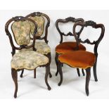 A pair of Victorian rosewood balloon back dining chairs, upholstered in overstuffed floral fa