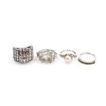 Four silver dress rings, comprising a cultured pearl and cz set twist ring, half hoop eternity ring,