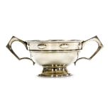 An Edward VII silver two handled cup, with angular handles, the top with a raised border with repeat