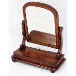 A Victorian mahogany swing frame toilet mirror, raised on a bow fronted base, 58cm high, 47cm wide.